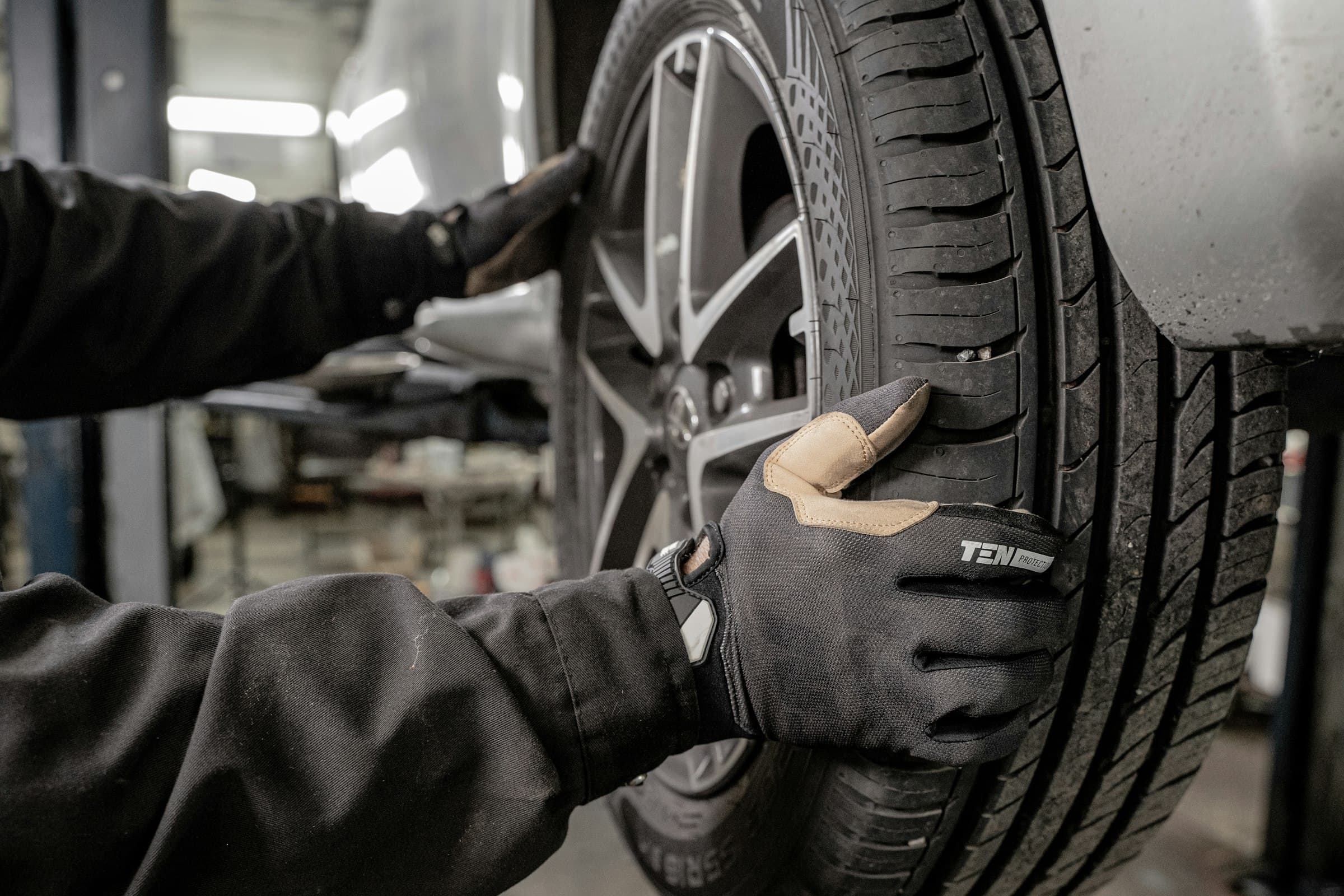A technician working on a car wheel in a garage
